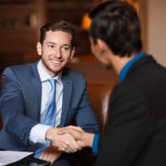 two-happy-partners-shaking-hands-cafe