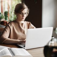 work-lifestyle-business-concept-good-looking-focused-european-female-trendy-glasses-sitting-cafe-near-laptop-working-notebook-surrounded-with-books-making-notes (1)